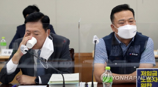 12일 오후 세종시 정부세종청사 최저임금위원회 회의실에서 열린 9차 전원회의에서 사용자위원인 한국경영자총협회 류기정 전무가 물을 마시고 있다. 오른쪽은 근로자위원인 이동호 한국노총 사무총장.<연합뉴스>